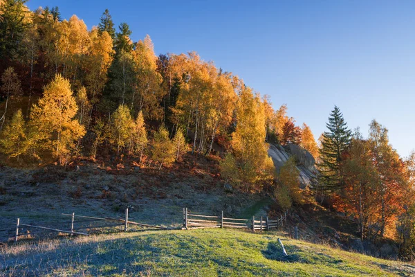 Podzimní krajina s dřevěným plotem v horské vesnici — Stock fotografie