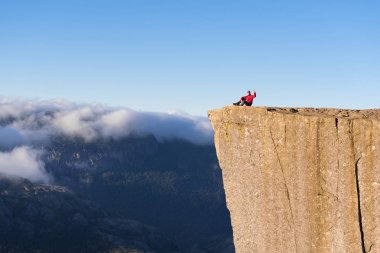 Guy on the Rock Preikestolen, Norway clipart