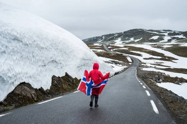 Mädchen mit norwegischer Flagge auf einer Bergstraße in Norwegen — Stockfoto