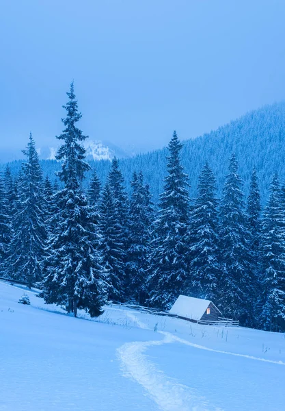 Winterlandschaft mit einem Haus in den Bergen — Stockfoto