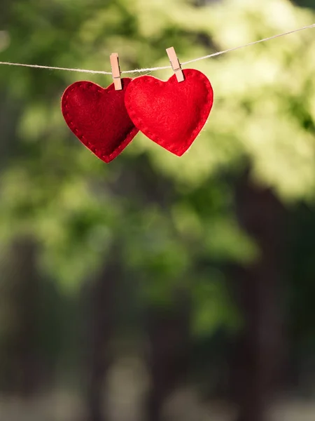 Biglietto di Giorno di San Valentino con un paio di cuori rossi su una schiena sfocata — Foto Stock