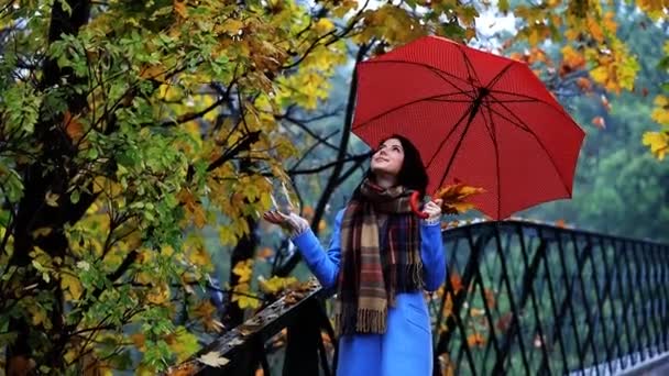 Жінка з червоною парасолькою в парку — стокове відео