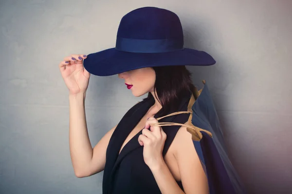 Kvinna i hatt med shopping väska — Stockfoto