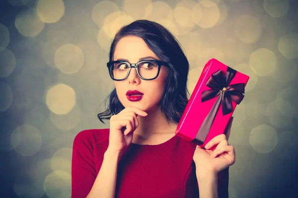 Mujer en vestido negro con regalo — Foto de Stock