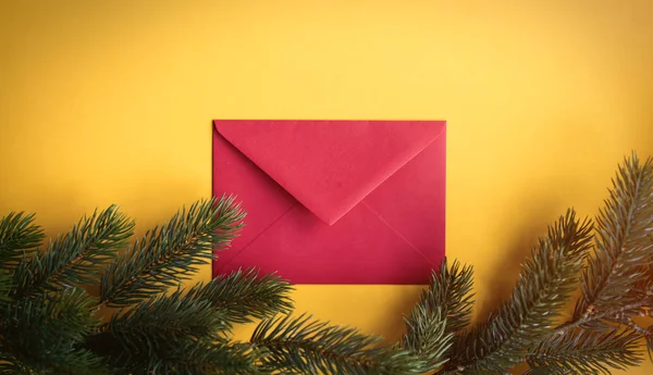 松の枝の近くの赤いクリスマス封筒 — ストック写真