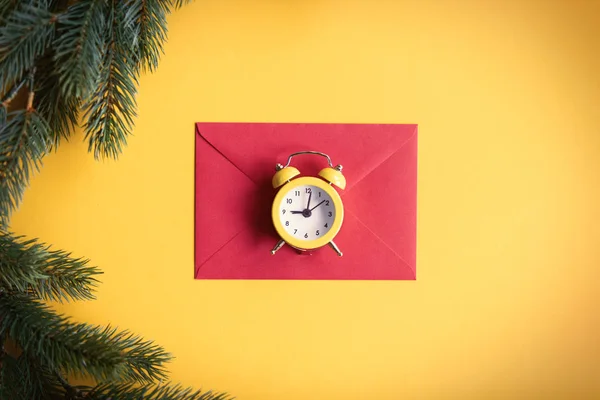 Envelope de Natal vermelho e pequeno despertador — Fotografia de Stock