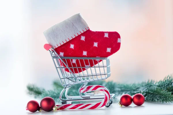 Carrinho de compras com meia de Natal e lolipop — Fotografia de Stock