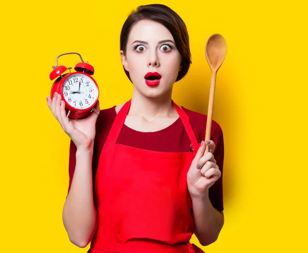 Housewife with red alarm clock and spoon — Stock Photo, Image