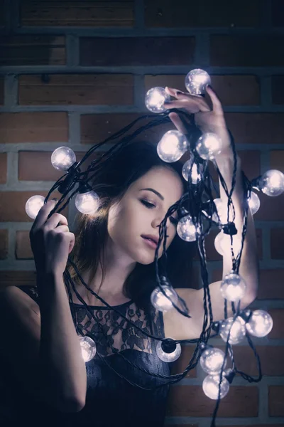 Jovem mulher com luzes de fadas — Fotografia de Stock