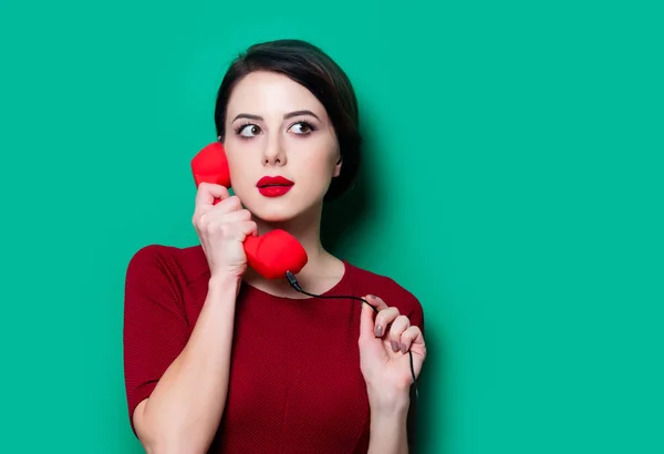 Portret van een jonge vrouw met rode handset — Stockfoto
