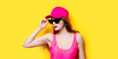 Pembe mayo ve moda şapkalı şık esmer kadın. Seksi la