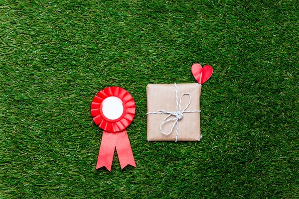 Récompense rouge et boîte cadeau sur fond d'herbe verte , — Photo