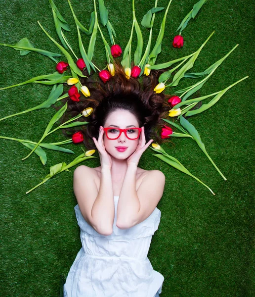 Retrato de uma jovem ruiva com tulipas e óculos — Fotografia de Stock