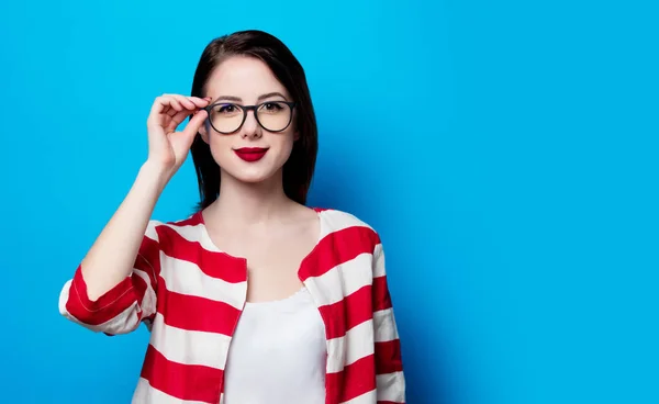 Portret van de mooie jonge lachende vrouw op de blauwe backgr — Stockfoto