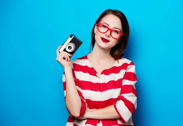 Jeune femme souriante avec caméra rétro — Photo