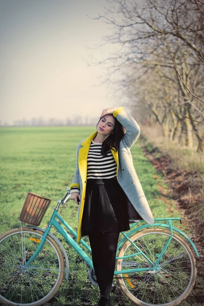 Mulher de pé com bicicleta — Fotografia de Stock