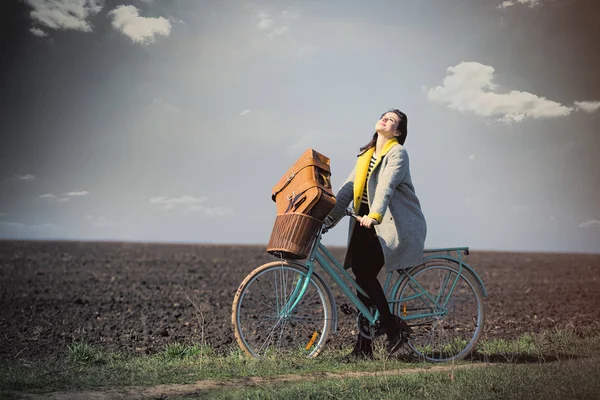 Жінка на велосипеді з валізою — стокове фото