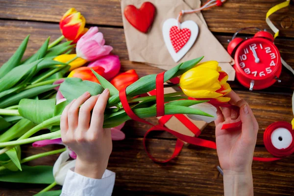 Ruce, obtékání tulipány — Stock fotografie