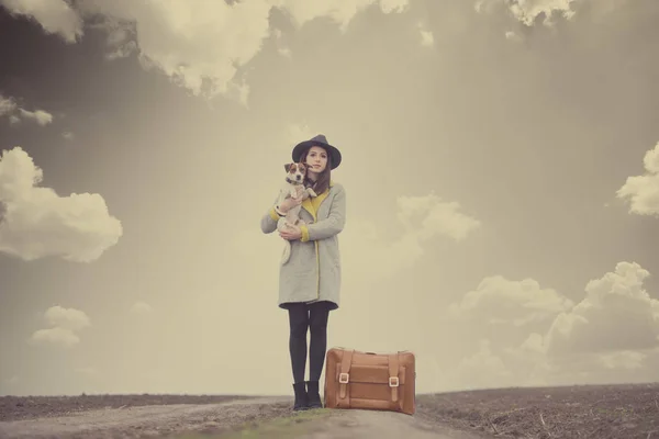 Женщина держит собаку возле чемодана Лицензионные Стоковые Изображения
