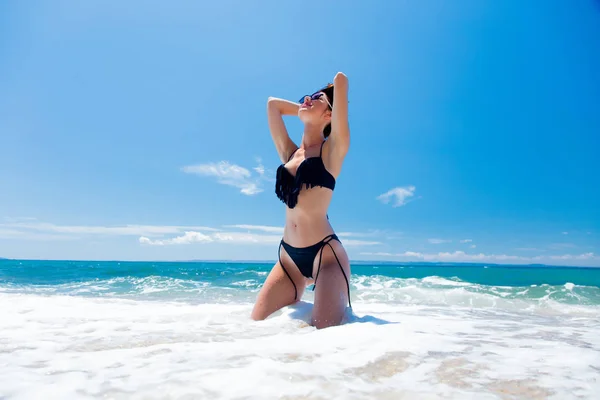 Vrouw die zich voordeed op het zandstrand — Stockfoto