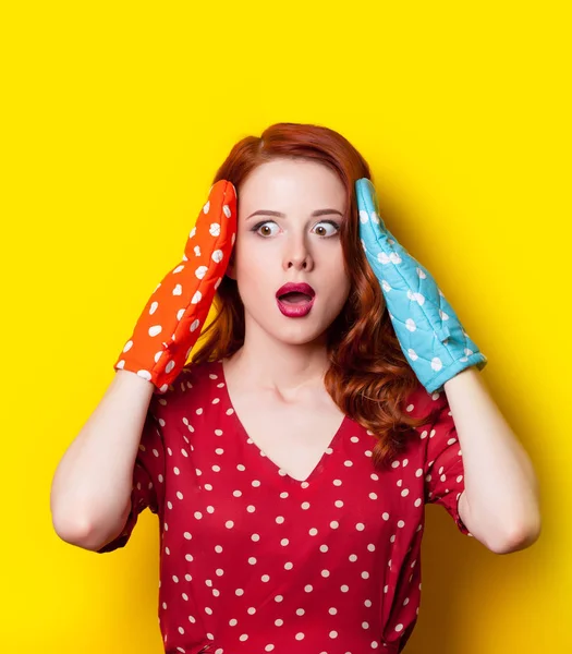 Jonge vrouw met kleurrijke pannenlappen — Stockfoto