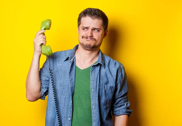 Homem segurando telefone retro verde — Fotografia de Stock