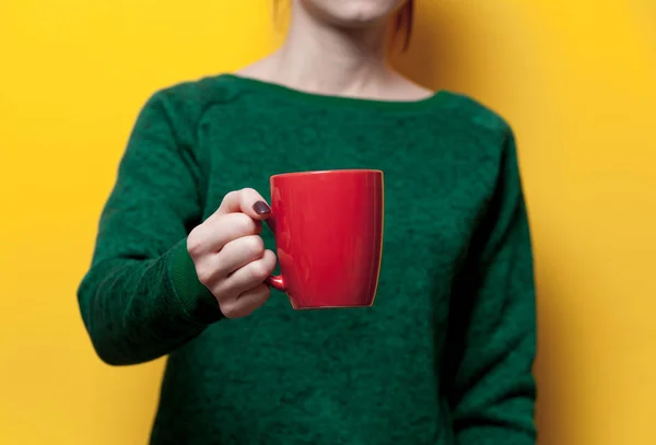 Mujer sosteniendo una taza roja — Foto de Stock