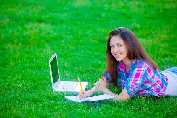 Ragazza con computer portatile e copybook — Foto Stock