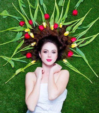 Sarı ve kırmızı laleler w üzerinde yalan yakınındaki güzel genç kadın