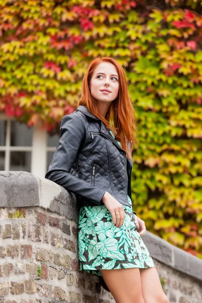 Piękna młoda kobieta stojąc w pobliżu ogrodzenie z kamienia i explorin — Zdjęcie stockowe