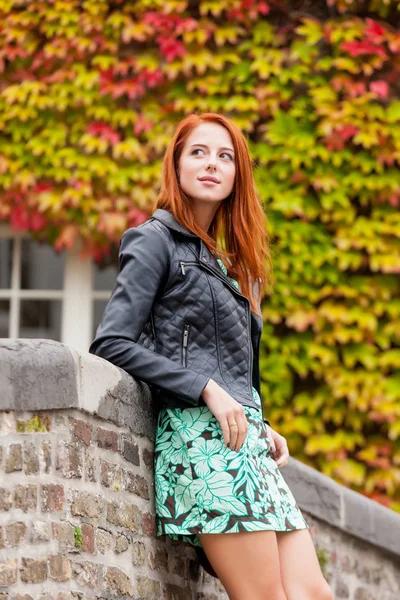 Beautiful young woman standing near the stone fence and explorin — Stock Photo, Image