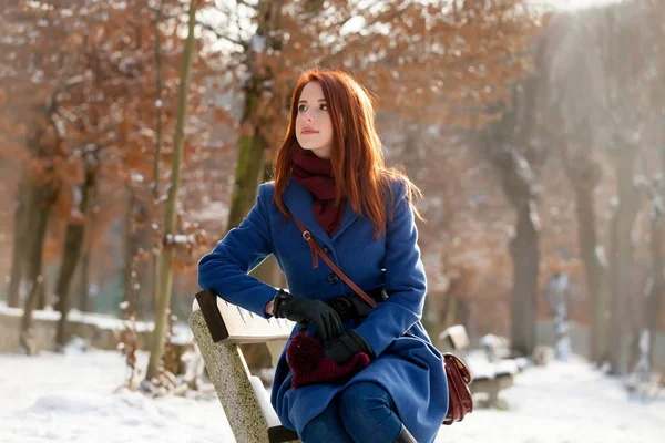 Photo of beautiful young woman sitting on the bench in the park — Stock Photo, Image