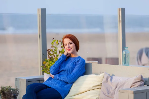 Όμορφη νεαρή γυναίκα που κάθεται στο καφενείο στην παραλία — Φωτογραφία Αρχείου