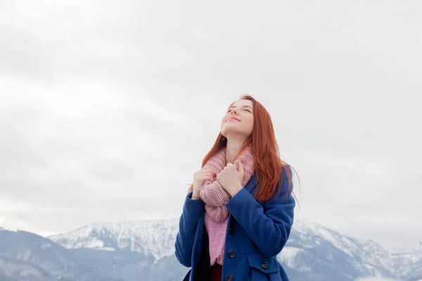 Beautiful young woman on the mountains background — Stock Photo, Image