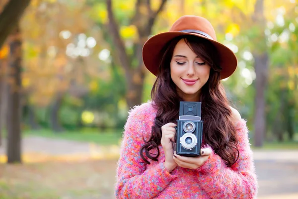 Photo of beautiful young woman standing in the park with retro c — Stock Photo, Image