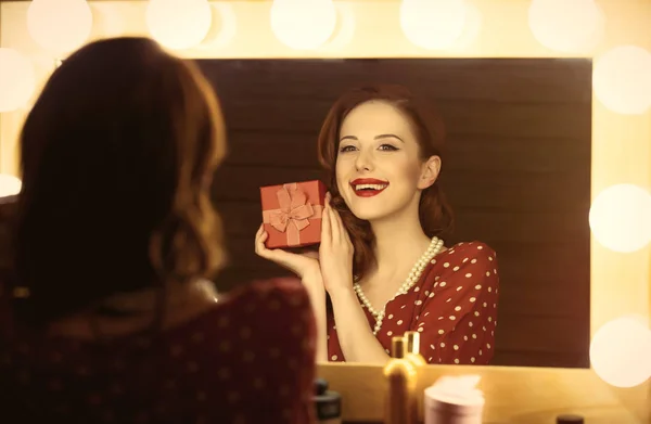 Foto de una hermosa joven sosteniendo su regalo cerca de la ventana — Foto de Stock