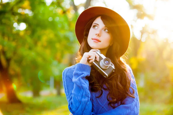 Фото красивой молодой женщины, стоящей в парке с ретро c — стоковое фото