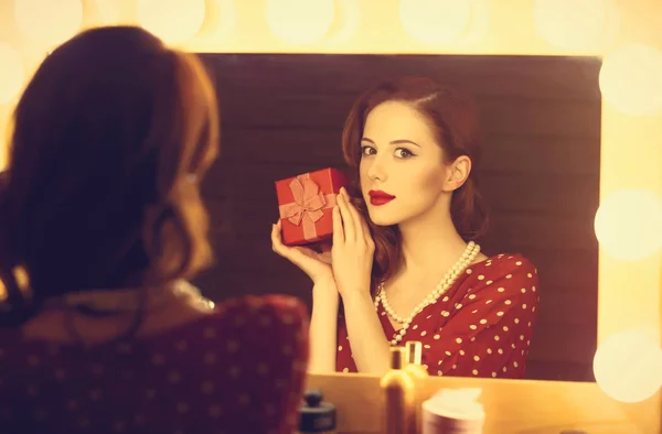 Foto de una hermosa joven sosteniendo su regalo cerca de la ventana —  Fotos de Stock