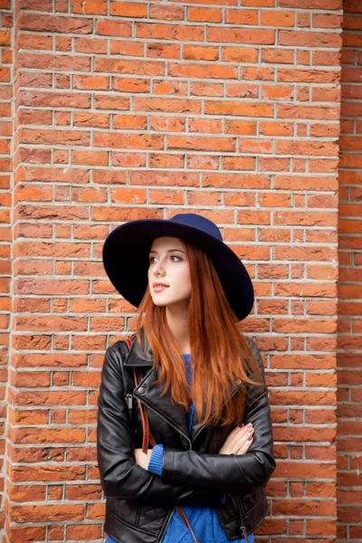 Hermosa mujer joven de pie cerca de la pared del edificio de ladrillos — Foto de Stock
