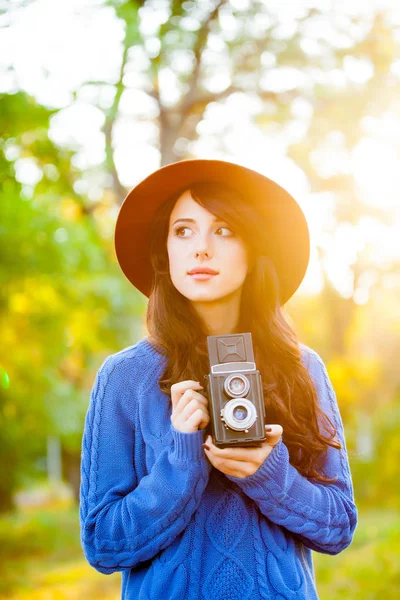 Foto krásné mladé ženy stojící v parku s retro c — Stock fotografie