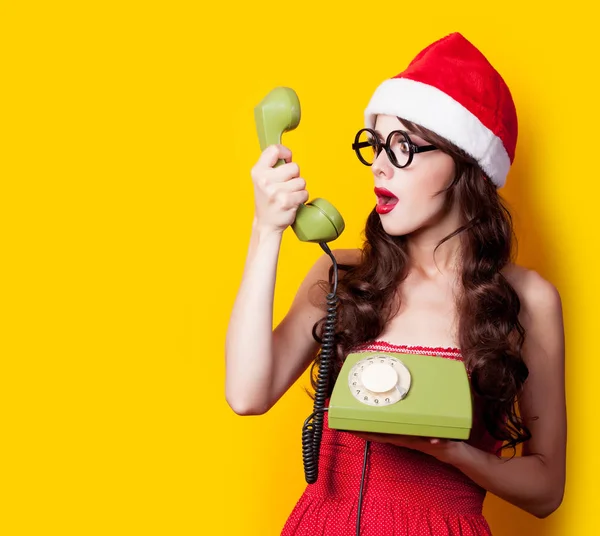 Photo of beautiful young woman with retro phone in santa claus h — Stock Photo, Image