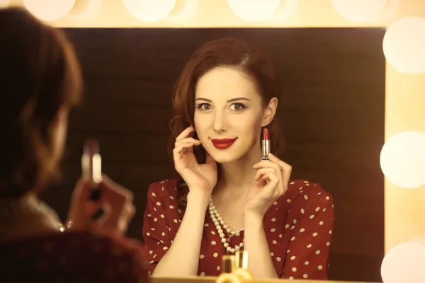 Photo of beautiful young woman holding her lipstick near the win — Stock Photo, Image