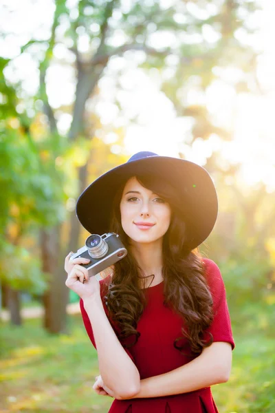 Foto van mooie jonge vrouw die permanent in het park met retro c — Stockfoto