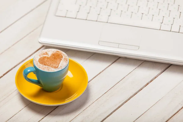 Hermosa taza azul de café y portátil — Foto de Stock