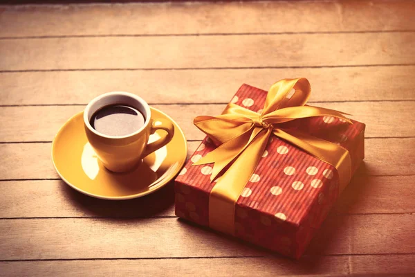 Cup of coffee and cute wrapped gift — Stock Photo, Image