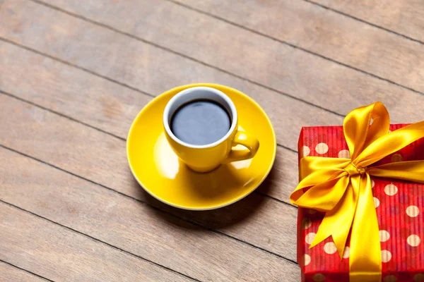 一杯のコーヒーとかわいいラップされたギフト — ストック写真
