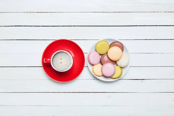Red cup of coffee and plate full of macaroons — Stock Photo, Image