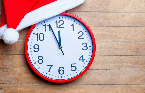 Relógio vermelho e chapéu de santa claus — Fotografia de Stock