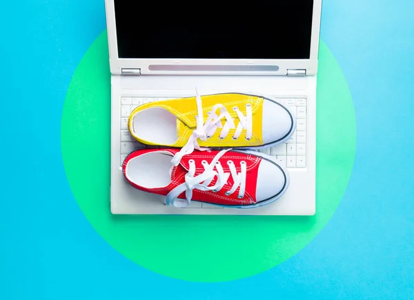Красочные кроссовки и серебряный ноутбук — стоковое фото