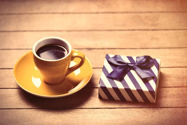 Cup of coffee and cute wrapped gift — Stock Photo, Image